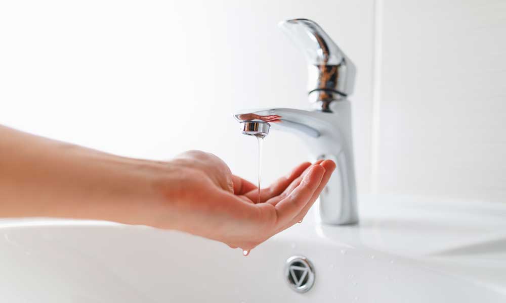 hand under the faucet collecting water